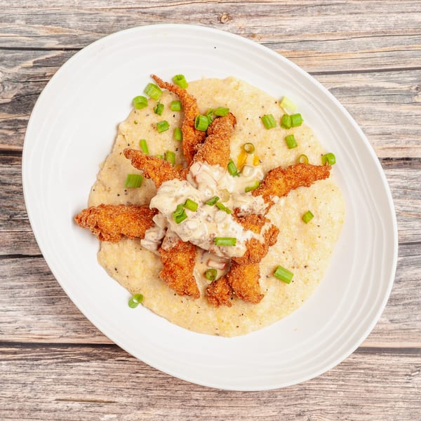 Crispy fried shrimp and creamy grits topped with a rich sauce and chopped green onions.